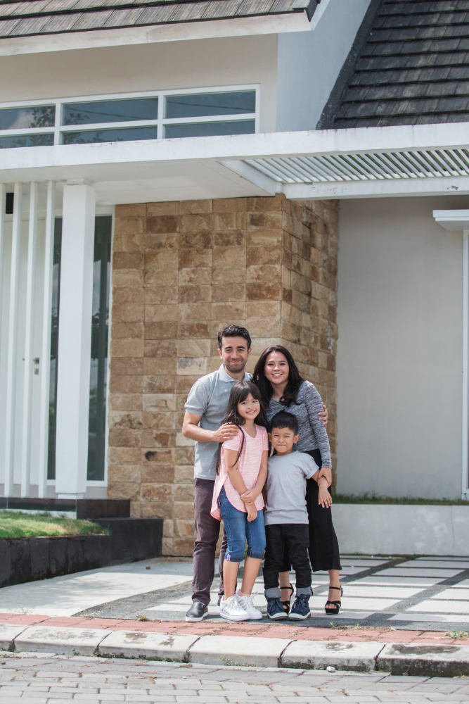 Familia latina frente a su casa nueva